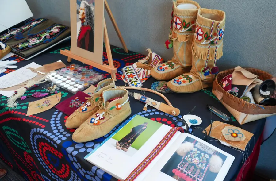 Métis floral beadwork, beaded moccasins and mukluks, and beading supplies displayed at a Manitoba Métis Federation event